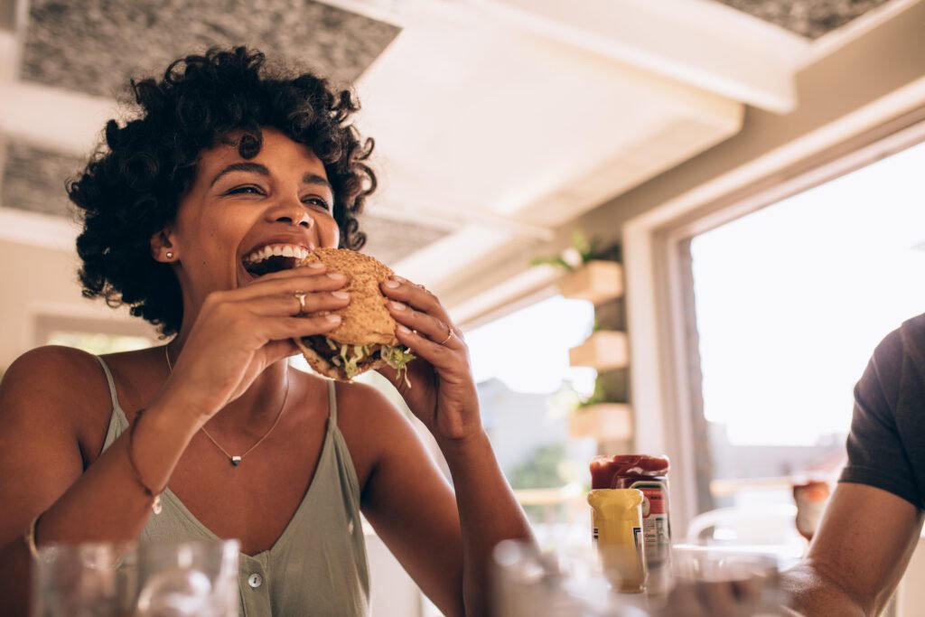 How Can You Enjoy Your Favorite Foods Without Worry? Discover the Dietary Freedom of Invisalign 10 Woman enjoying eating burge