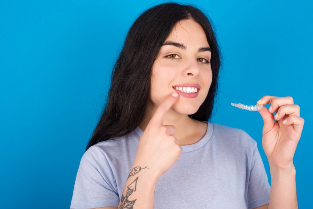 How Does Invisalign Utilize Transparent Aligners to Adjust Your Teeth Gradually? 1 young beautiful tattooed girl